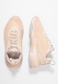 Baskets rose clair combinant du daim et du mesh, avec une forme arrondie, des semelles en caoutchouc texturées et des lacets contrastants.