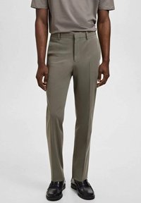 Slim-fit broek in olijfgroen, gemaakt van gladde stof. Heeft een platte voorkant, zijzakken en een tailleband met riemlussen.