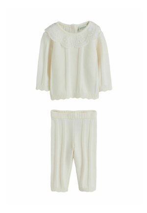 Tenue de bébé tricotée couleur crème avec pull à manches longues à col en dentelle et pantalon côtelé assorti avec motif torsadé.