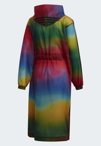 Dlouhá, lehká, kapucí zdobená bunda s živým gradientem červené, modré, zelené a žluté barvy. Elastické manžety a detail stahovacího pásku na bocích.