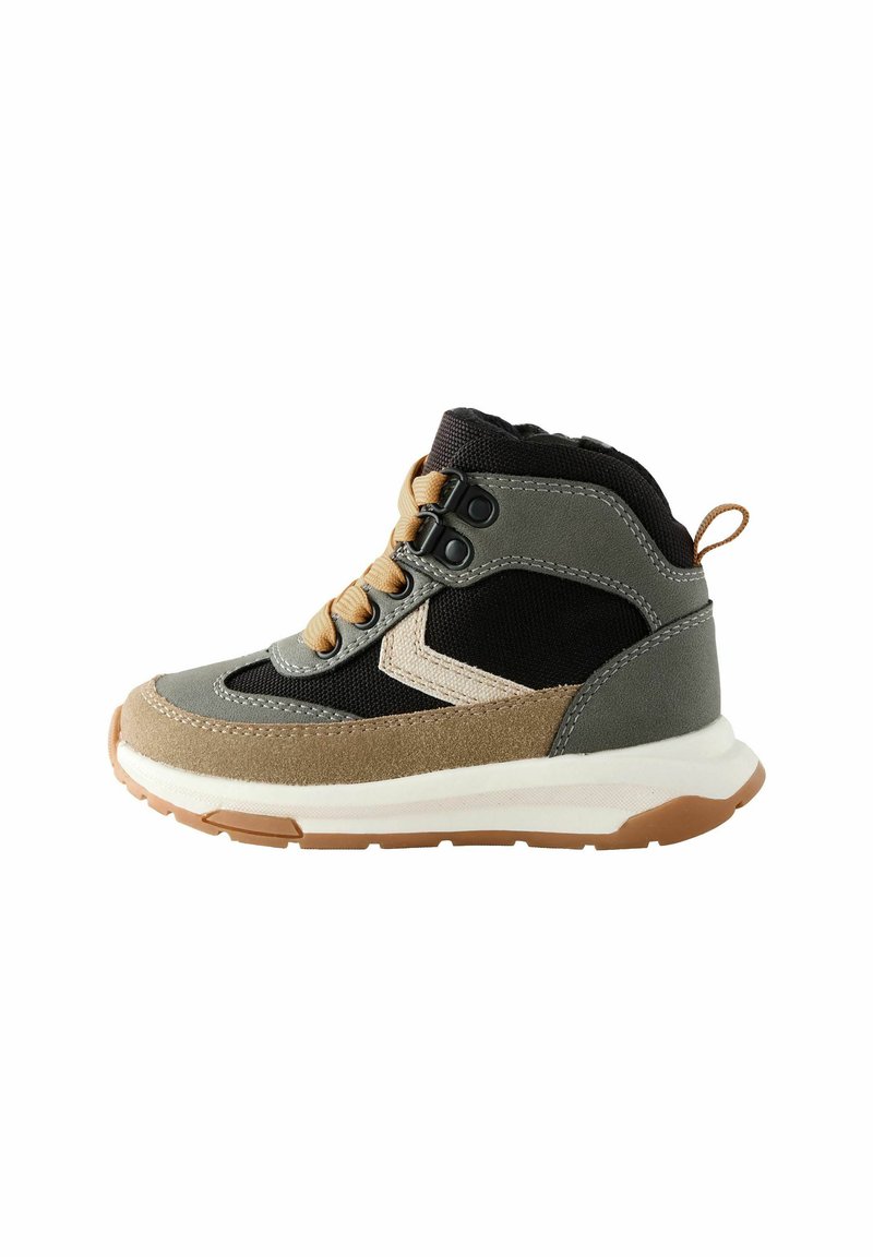 Buty typu mid-top z szarym materiałem, czarną siateczką i akcentami z brązowego zamszu. Posiadają białą gumową podeszwę, brązową gumową podeszwę zewnętrzną oraz beżowe sznurówki.