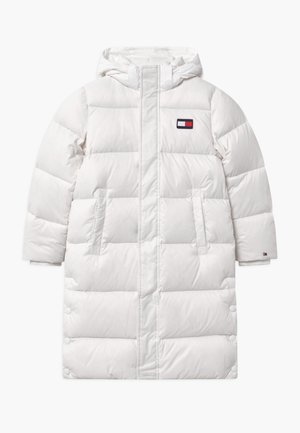 Long manteau d'hiver matelassé blanc avec capuche, poches avant, et un petit logo rectangulaire rouge, blanc et bleu sur la poitrine et la manche.