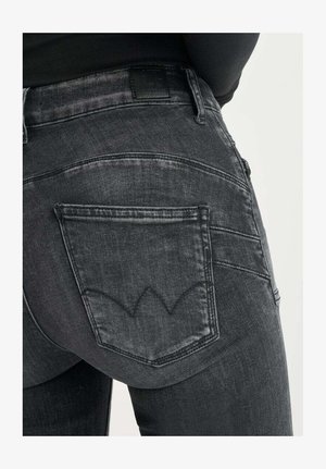 Zwarte spijkerbroek van denim met een nauwsluitend ontwerp, opvallende achterzakken en een onderscheidend gestikt patroon op de achterzak.