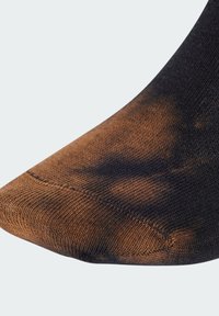 Calza con gradiente nero e marrone, caratterizzata da un motivo di maglia testurizzata, con punta a punta e dettagli di cuciture rinforzate sulla cucitura.