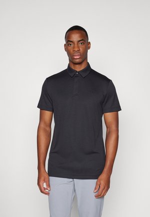 Black polo shirt with a collar and short sleeves. Made of smooth fabric, featuring a subtle logo on the chest. Classic fit.