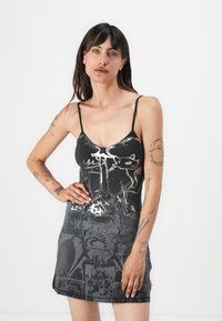 Black sleeveless dress with silver graphic print, featuring a fitted design and lightweight fabric. Includes thin adjustable straps.