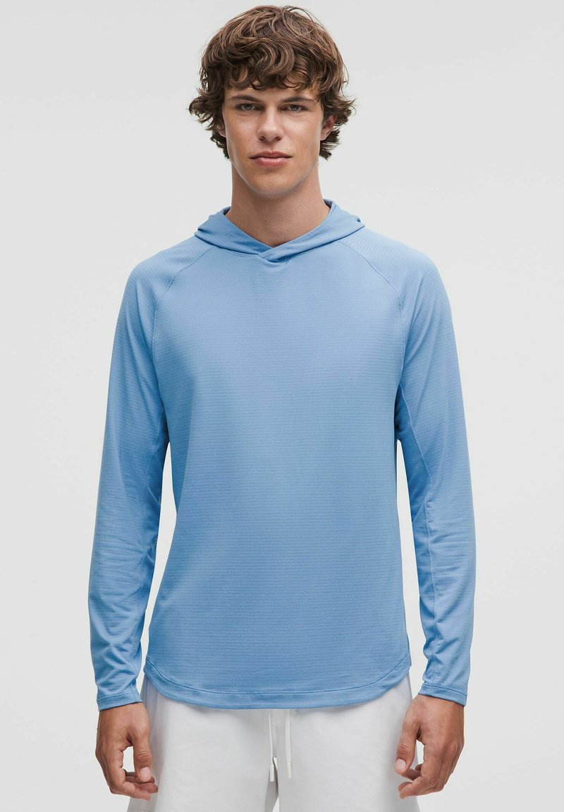 Lichtblauw langemouw hoodie shirt van gestructureerde stof, met een relaxte pasvorm en raglanmouwen, gecombineerd met witte broek met trekkoord.