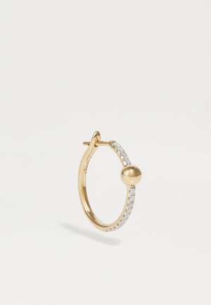 Une boucle d'oreille en or possède un petit accent sphérique, orné d'une rangée de pierres claires et scintillantes sur le devant. Surface lisse et polie.