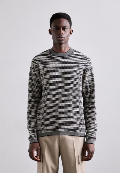 Zwart-wit gebreid sweater met een ronde hals en lange mouwen. Gemaakt van een textuurmateriaal, met een horizontale streepdessin.