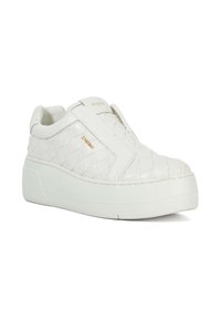 White woven synthetic slip-on sneaker with a thick white sole and a small gold logo accent on the side. Smooth texture, minimal design.