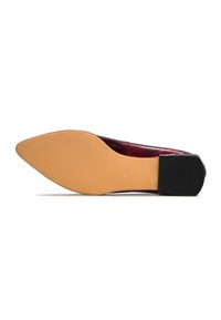Chaussure plate avec un bout pointu, présentant un dessus en cuir bordeaux lisse et une semelle extérieure en caoutchouc beige. Accent de talon noir à l'arrière.