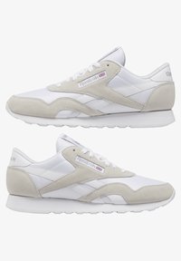 Weiß und hellgraue Sneaker aus Wildleder und synthetischen Materialien, mit Schnürdesign, gepolstertem Kragen und Reebok-Branding.
