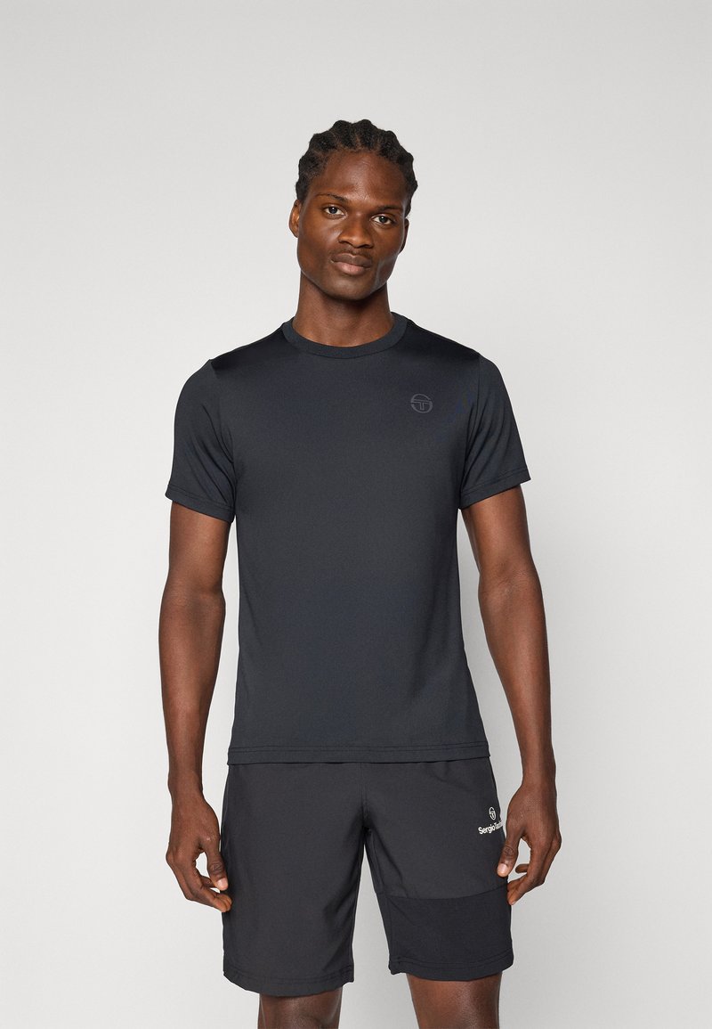 Μαύρο αθλητικό μπλουζάκι με κοντά μανίκια, απαλό ύφασμα, στρογγυλή λαιμόκοψη, διακριτό λογότυπο στο στήθος, συνδυασμένο με μαύρες βερμούδες που έχουν πλαϊνή τσέπη.