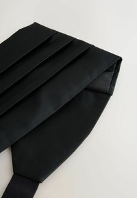 Black pleated necktie with a textured finish. The fabric features contrasting ribbed patterns and a smooth underside. Adjustable strap included.
