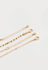 Επεκτάσεις αλυσίδας σε απόχρωση χρυσού με τρία σχέδια: μία με πολύχρωμες χάντρες, δύο με απλούς κρίκους, όλες με μηχανισμό κλεισίματος.