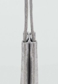 Gray fabric tote with two long handles, featuring a vertical stripe pattern and a flat base, highlighted by a soft texture.