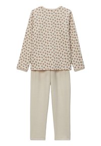 Ensemble de pyjama deux pièces comprenant un haut à manches longues avec un fond crème et un motif en cœurs marron, associé à un pantalon crème uni.