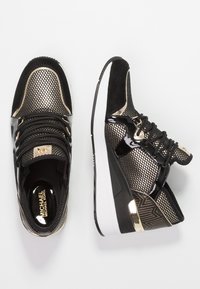 Czarne sneakersy z złotymi akcentami, wykonane z siateczki i materiałów lakierowanych, z wyściełaną podeszwą oraz teksturowanym wzorem na pięcie.