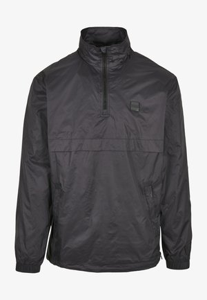 Zwarte pulloverjack in lichtgewicht, waterafstotend materiaal. Voorzien van een kwart-rits hals, elastische manchetten en een voorkeurszak. Eenvoudig ontwerp.