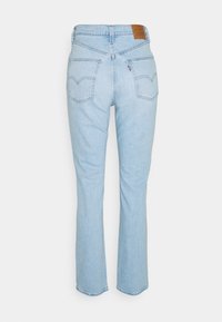 Jeans de tiro alto, rectos y de color azul claro, con bolsillos traseros, trabillas para el cinturón y un parche de marca de cuero marrón en la cinturilla.