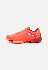 Scarpe sportive rosse con parte superiore in rete, dotate di un logo Puma bianco e rosso, chiusura con lacci e suola texturizzata per la presa.