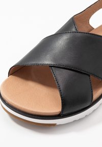 UGG Sandaalit nilkkaremmillä - black