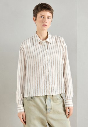 Pitkähihainen napillinen paita vaaleanbeigessä, jossa on kapeat pystysuorat raidat. Ominaisuuksiin kuuluu klassinen kaulus ja kontrastiväriset raidalliset hihansuut. Teksturoitu kangas.