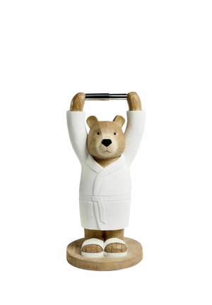 Wooden bear statue wearing a white bathrobe and slippers, holding a metal bar above its head, standing on a round wooden base.