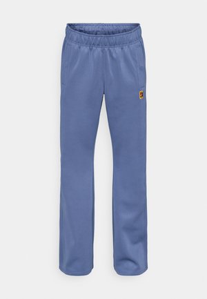 Blauwe sweatpants met een elastische tailleband, zijzakken en een klein, meerkleurig logo-inking bij de linkerzak. Zachte stoftextuur.