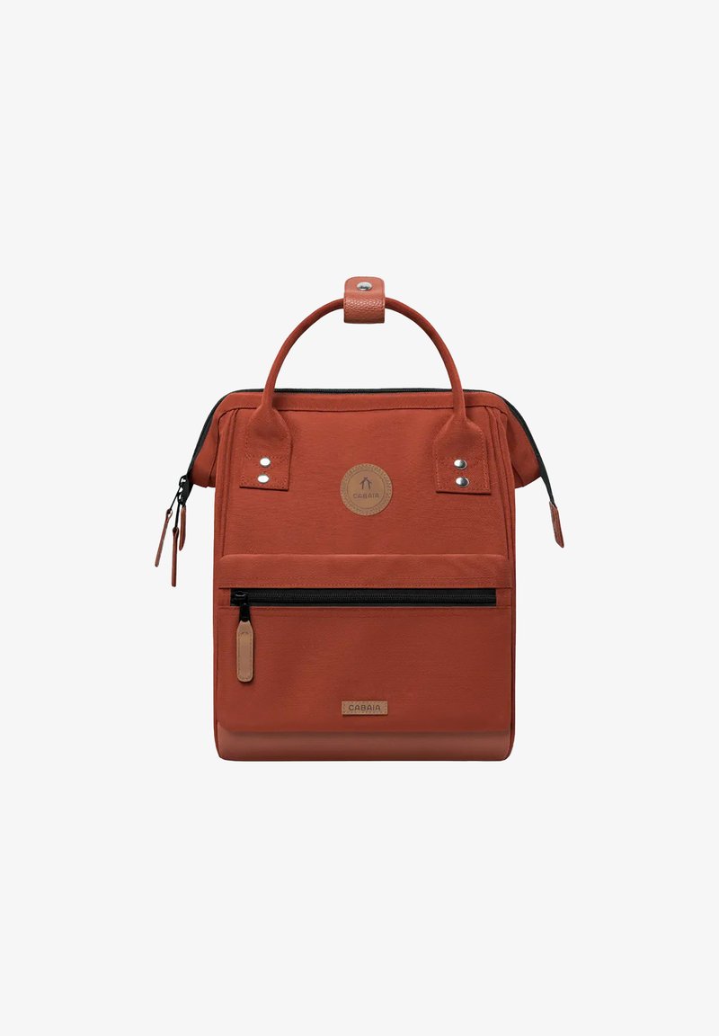 Rust-colored rectangular backpack with top handles, front zip pocket, and visible brand logo on front panel.