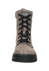 Beige enkellaars van gestructureerd leer met zwarte veters, contrasterende zwarte zool en subtiel gespikkeld patroon door het geheel.