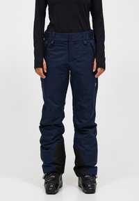 Marineblå vandtætte skibukser med høj talje, to frontknapper og sorte detaljer ved anklerne. Stoffet er glat og struktureret.