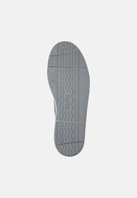 Grijze rubberen buitenzool met geprofileerde loopvlakken, gekenmerkt door zigzag- en horizontale lijnen voor grip. Gekenmerkt met het "CAMPER" logo.