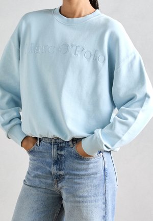 Light blue sweatshirt with embroidered "Marc O'Polo" text, featuring a round neck, dropped shoulders, and soft cotton blend fabric.