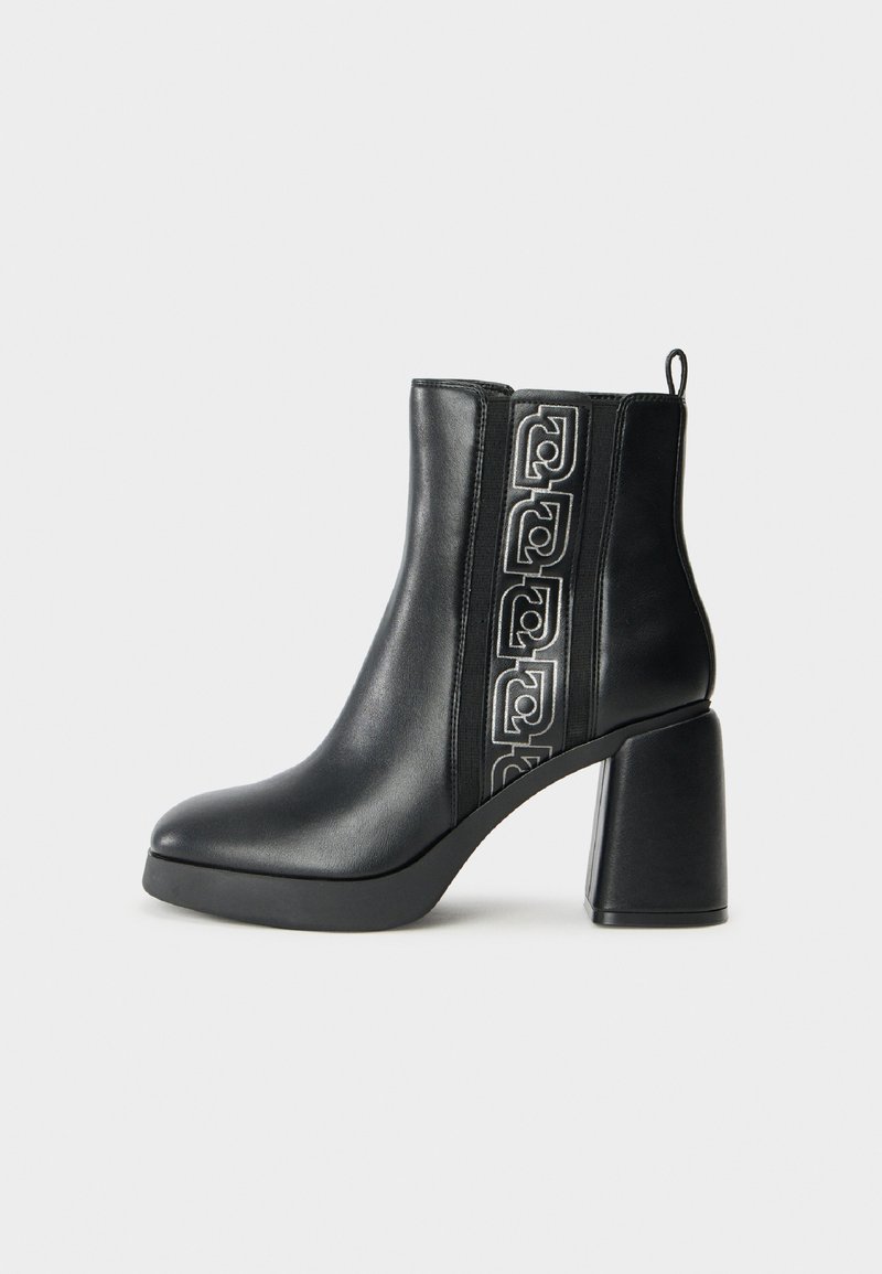 Zwarte leren enkelboots met een geometrisch reliëfdesign, chunky blokhak en elastische zijpanelen voor eenvoudig aan- en uittrekken. Glad oppervlak overal.