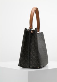 Black textured handbag with a brown leather handle, geometric pattern, and a tapered silhouette. Features gold-tone hardware and a zip closure.