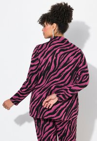 Fuchsia och svart zebra-randig, texturerad kavaj med långa ärmar och notch-krage, i kombination med matchande byxor, sedd bakifrån.