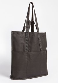 Sac fourre-tout noir en tissu durable avec deux longues anses, doté d'une forme structurée et d'une poche avant pour un rangement supplémentaire.