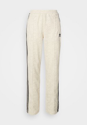 Cremefarvede joggers med et struktureret, slangeskindsmønster. Har sorte sidelister og en elastisk talje. Sort logoaccent på låret.