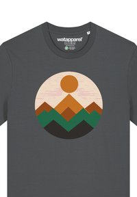 T-shirt gris foncé avec un graphisme circulaire représentant un soleil, des montagnes superposées dans des teintes d'orange, de vert et de noir, sur un fond texturé.