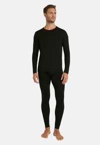 Black long-sleeve shirt and leggings made of soft fabric, featuring a fitted design and crew neckline. Legs are tapered with no visible patterns.