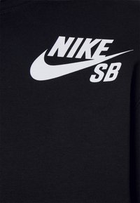 Zwarte sweatshirt van katoen, met een wit "NIKE" logo met een swoosh en "SB" tekst, gelegen aan de bovenste linkerkant.