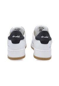 White sneakers with black textured heel accents, featuring a lightweight design and rubber gum outsoles. Branding is visible on the heel.