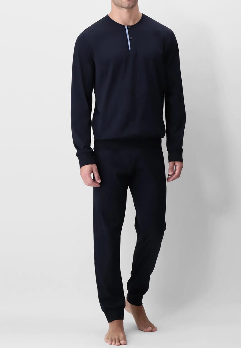 Set di abbigliamento casual navy composto da una maglietta a maniche lunghe con scollatura henley e dettagli a bottoni in contrasto, abbinata a pantaloni tapered coordinati.