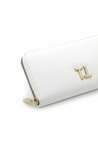 White wallet with textured faux leather, gold hardware, and a zip closure. Features a minimalistic embossed logo on the front.
