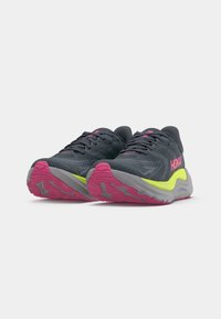 Sportieve schoenen met een donkergrijze mesh bovenkant, roze en gele accenten, een gevoerde grijze zool en een gestructureerde loopzool voor grip.