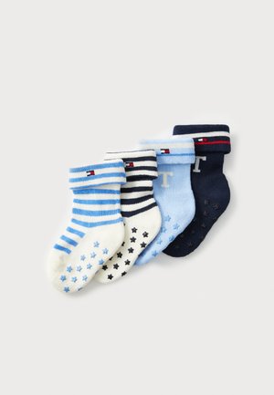 Fyra par barnsockor i olika nyanser av blått, vitt och marinblått, med ränder och stjärnmönster, samt ribbade mudd.
