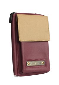 Maroon fabric pouch with a tan flap, featuring a brass logo plate and zip closure, showcasing a smooth texture and structured shape.