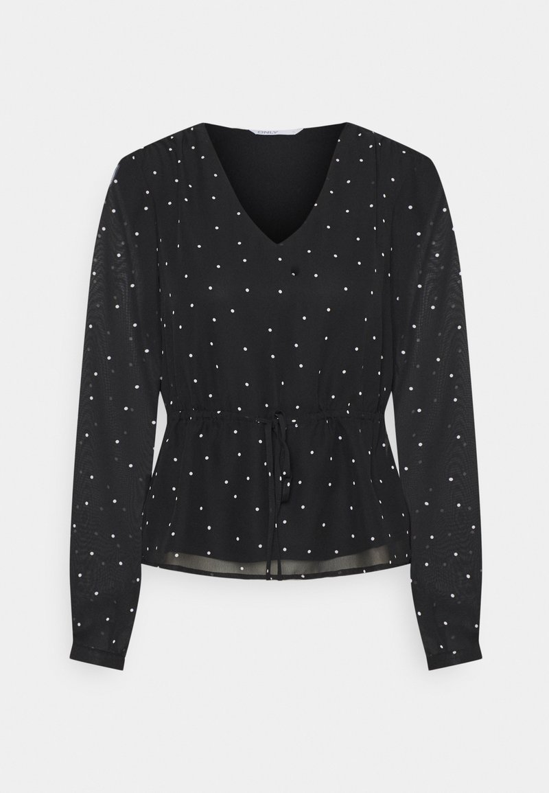 Blouse noire à manches longues avec des pois blancs, col en V, taille cintrée avec cordon, et tissu légèrement transparent.