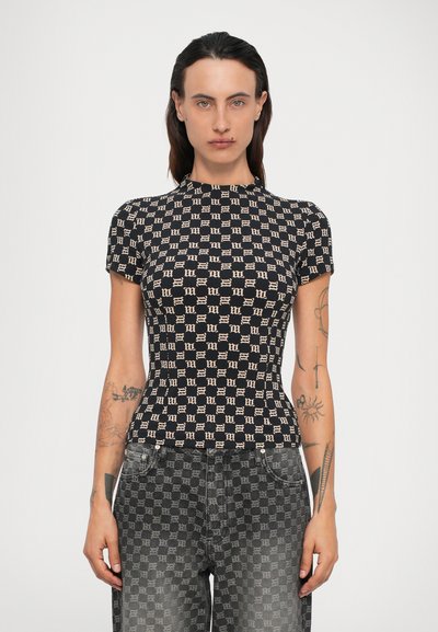 Top scurt, negru, cu un model geometric bej, având un decolteu înalt. Asortat cu blugi închiși la culoare, cu un model.